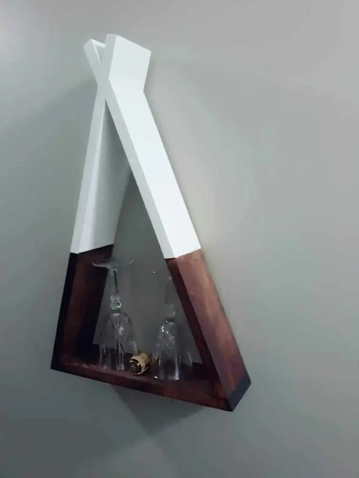 Handcrafted wooden teepee shelf mounted on wall, displaying glassware.