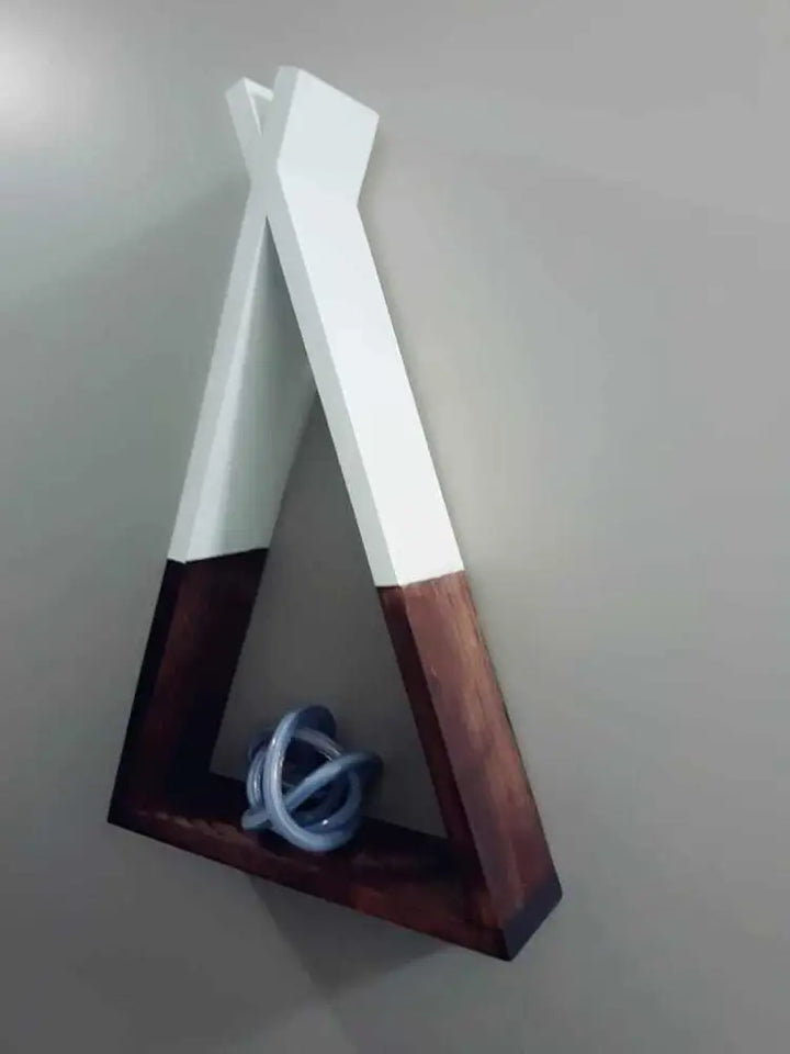 Handcrafted Teepee Shelf in white and wood tones mounted on wall, showcasing decorative item.