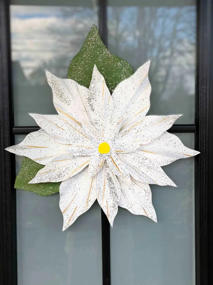 Wooden Poinsettia flower decoration on door, symbolizing holiday spirit and tradition.