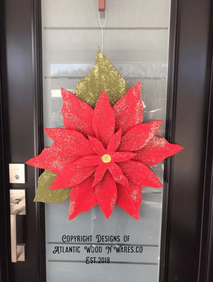 Wooden poinsettia flower decoration on door for holiday season.