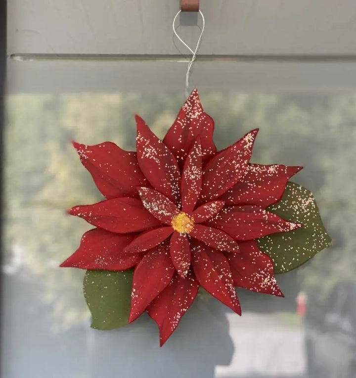 Wooden poinsettia decoration with vibrant red leaves symbolizing the holiday season.