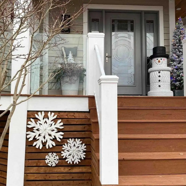 Handmade snowflake door decorations in winter-themed home setting.