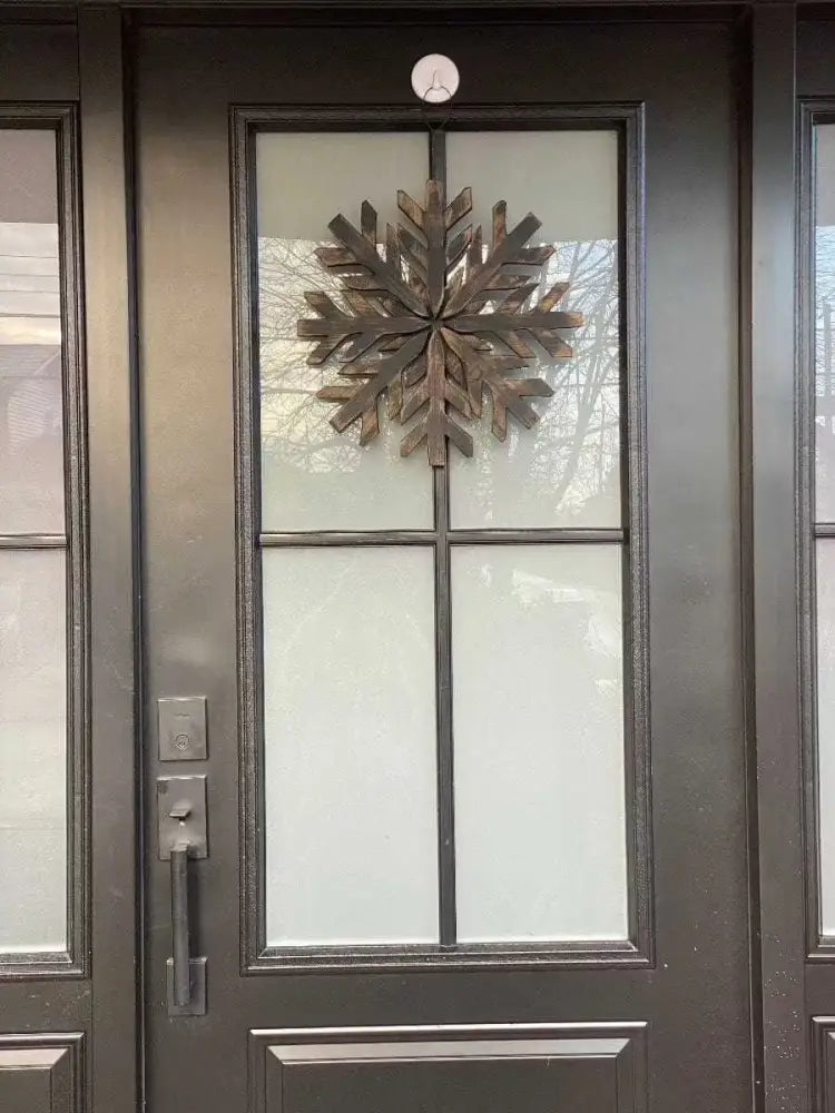 Handmade wooden snowflake decoration on a front door.