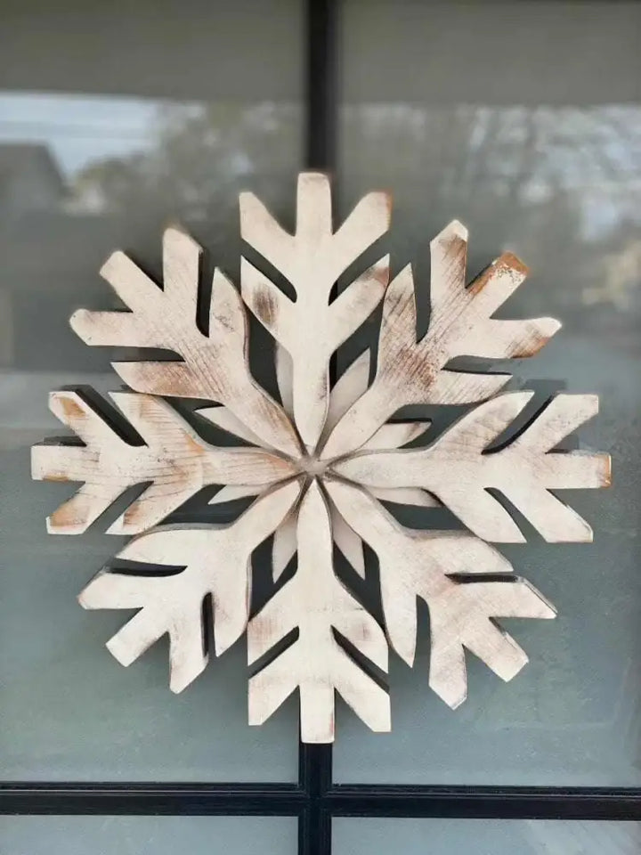Handmade wooden snowflake decoration with rustic appeal for winter door decor.