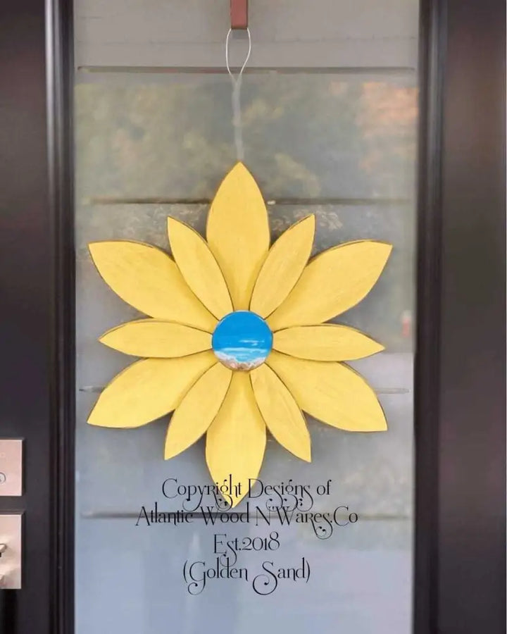 Yellow wooden flower door decoration with unique blue resin center, handcrafted in Nova Scotia by Woodnwares.