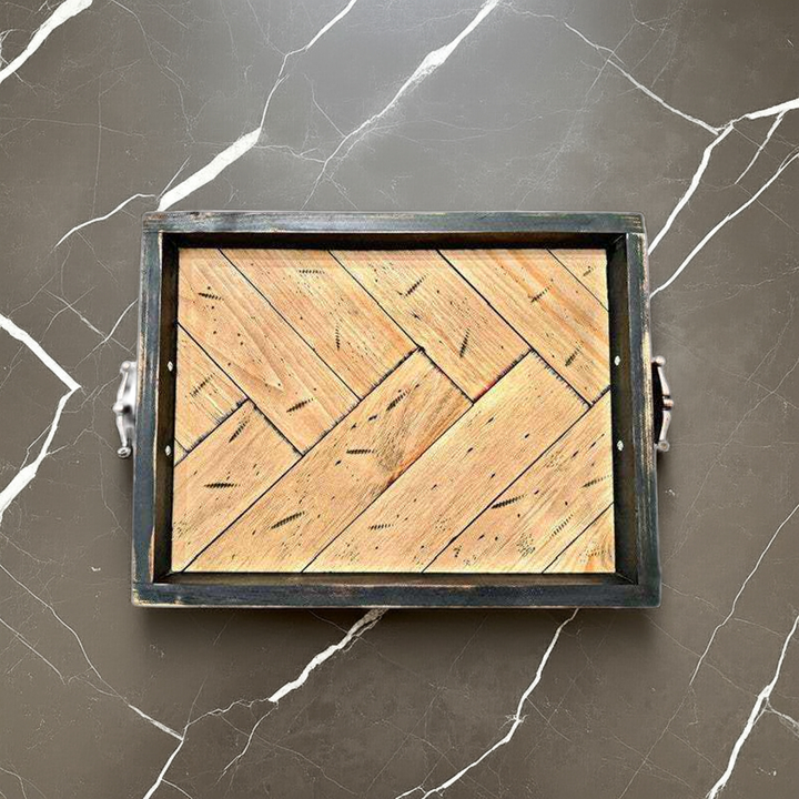 Antiqued herringbone wood tray with elevated feet and brushed copper handles on marble surface