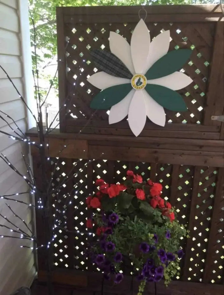 Handcrafted wooden flower door decoration with Cape Breton Tartan design, displayed outdoors.