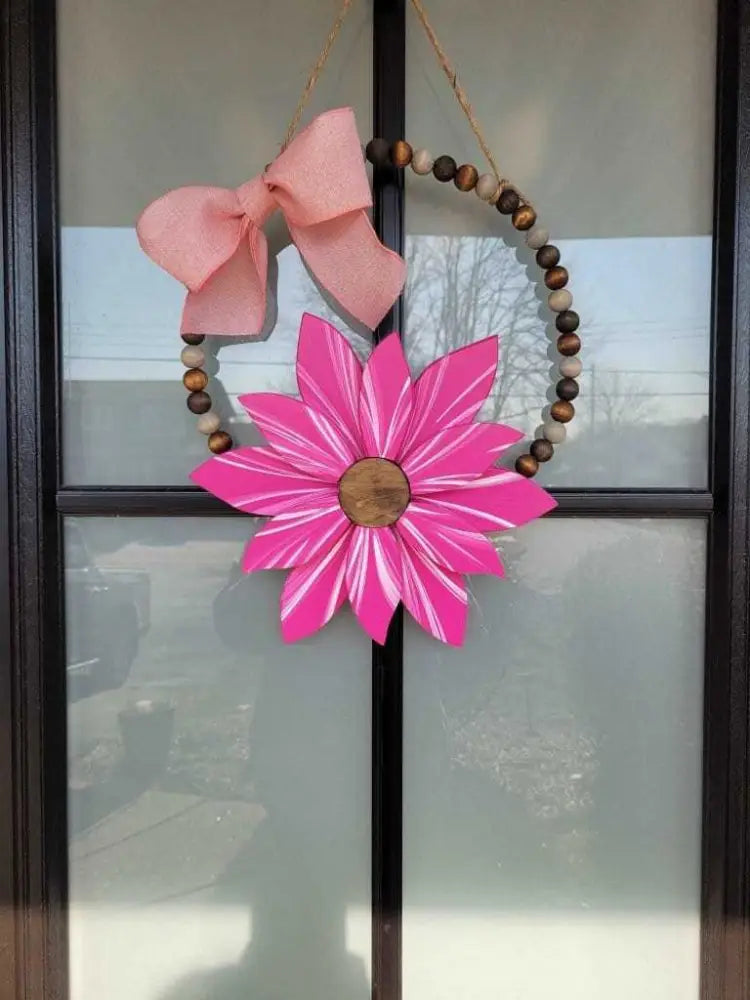 Boho style wooden bead wreath with a hand-painted pink wood flower.