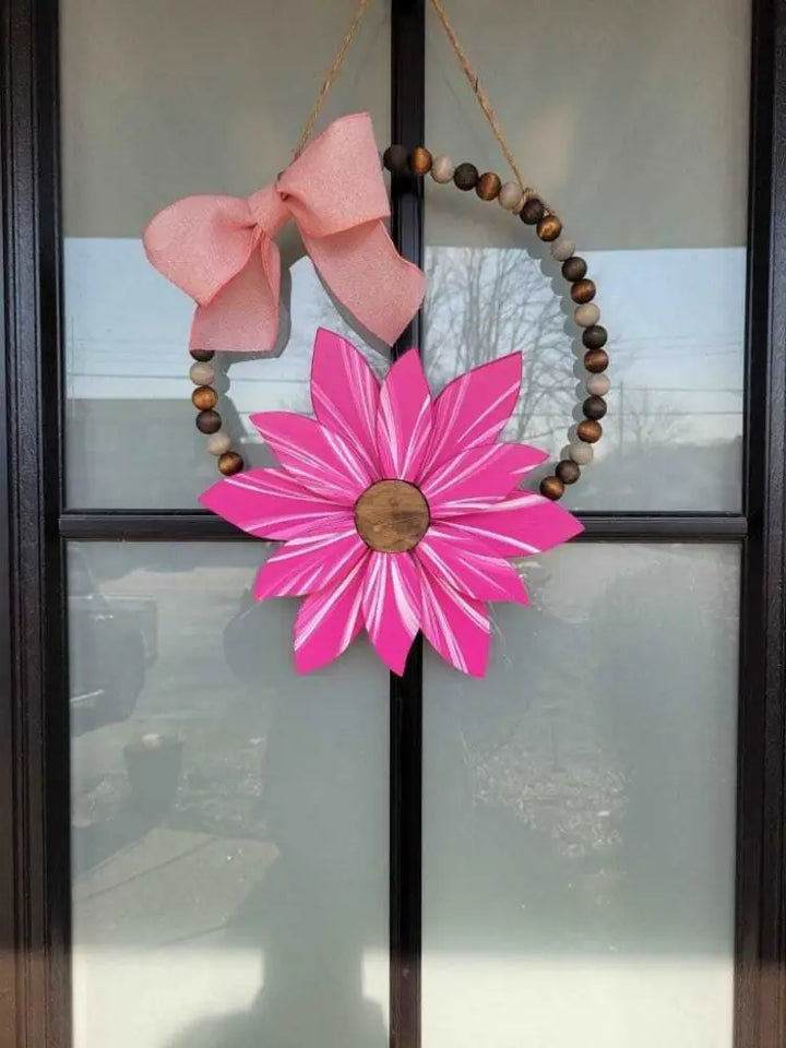 Boho style wooden bead wreath with a hand-painted pink wood flower.