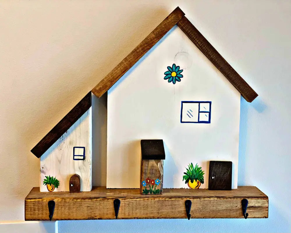 Handmade wooden village house key chain holder with hooks for wall hanging.